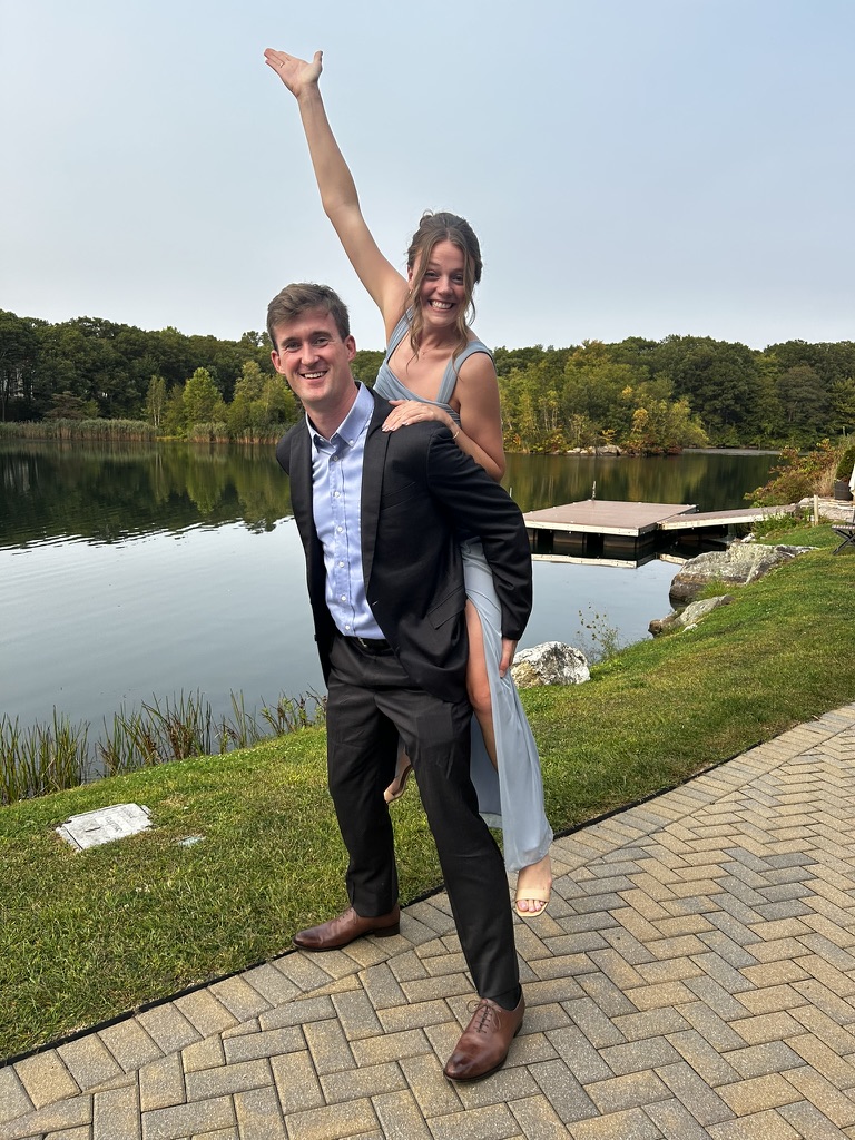 William giving Melissa a piggyback ride by a lake